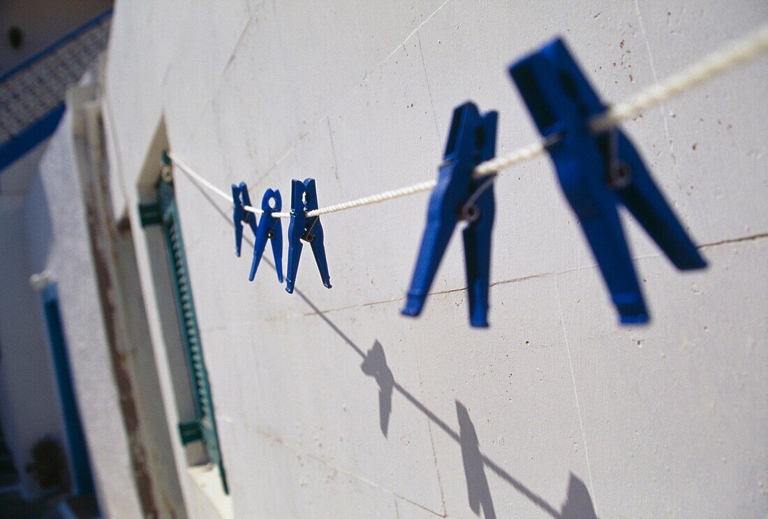 Washing Line Against House With Blue Clothes Pins