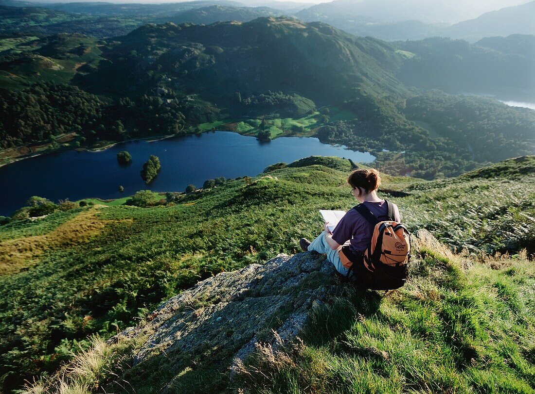 Walker Resting And Looking At Map Above Rydal Water