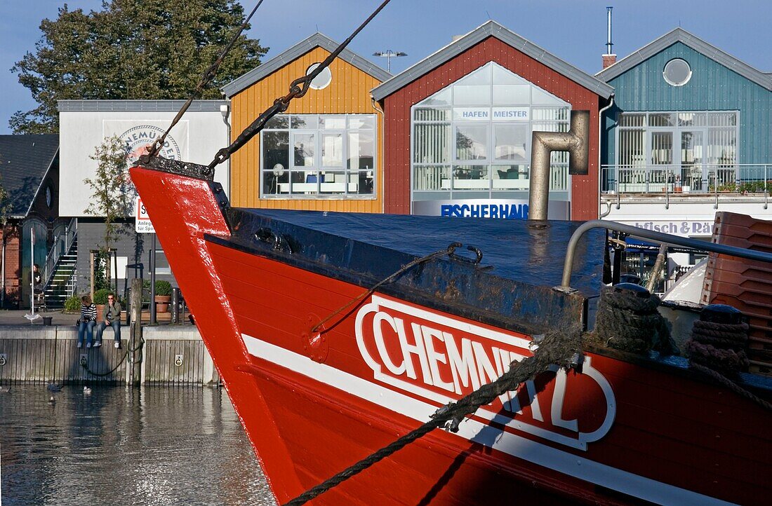 Fischerboot im Hafen zwischen bunten Häusern