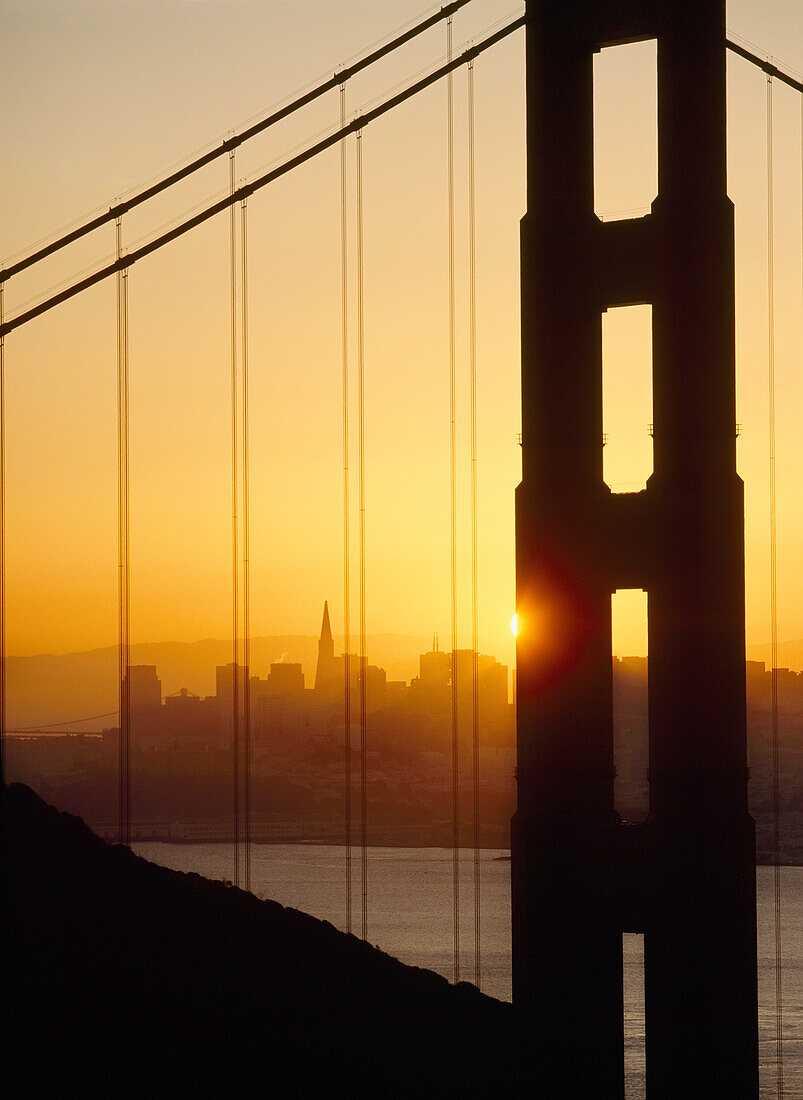 Sonnenaufgang hinter der Golden Gate Bridge mit San Francisco im Hintergrund