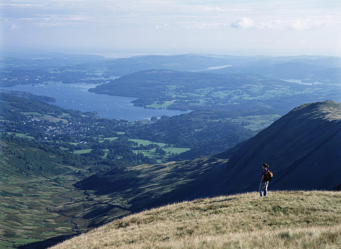 Wanderer bewundert die Aussicht beim Abstieg vom Rydal Head mit Blick auf Ambelside und den Lake Windermere