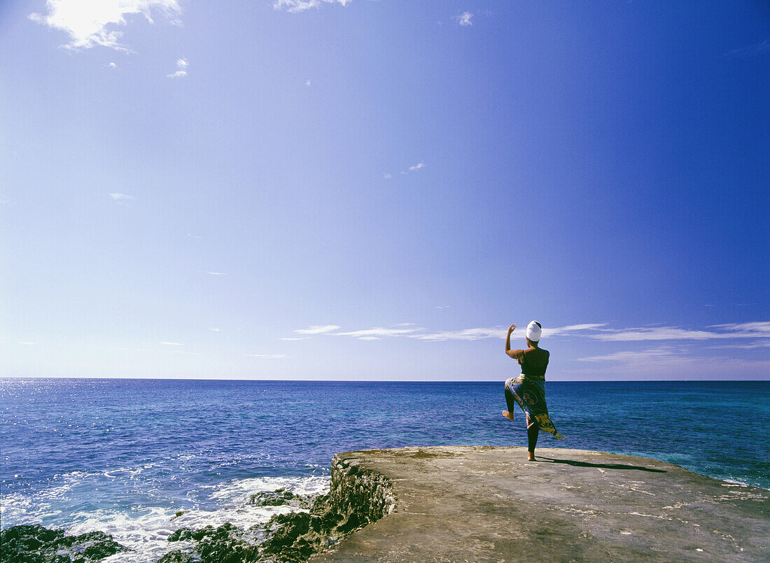 Frau übt Tai Chi am Meer