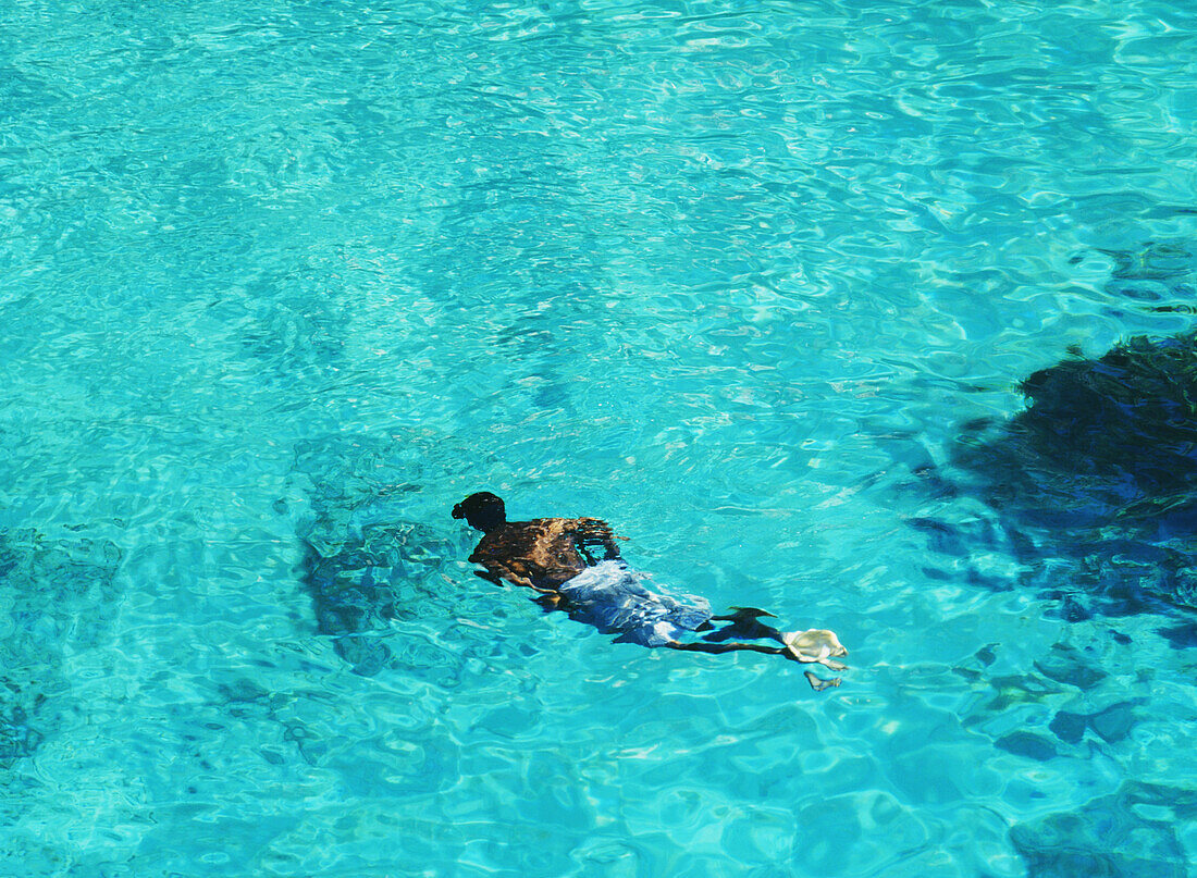 Man Swimming In The Sea Off The Cliffs Of Negril