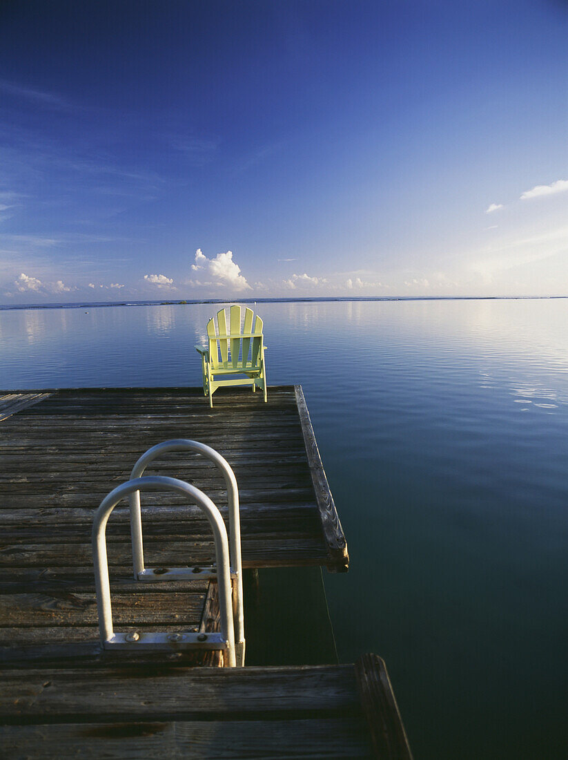 Chair On End Of Pier Beside Steps At Dawn