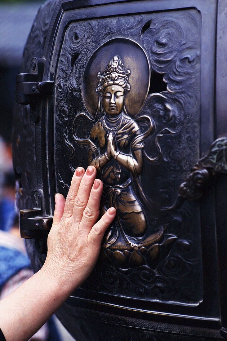 Berühren eines heiligen Bildes am Großen Buddha, Nahaufnahme