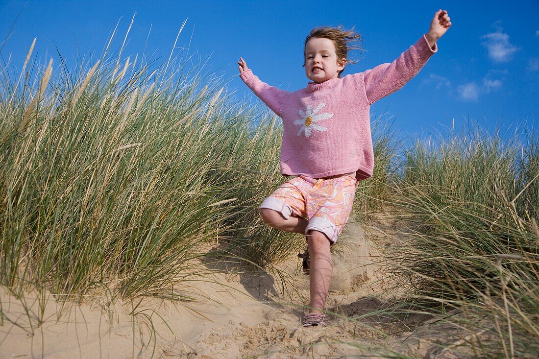 Mädchen rennt Sanddüne hinunter