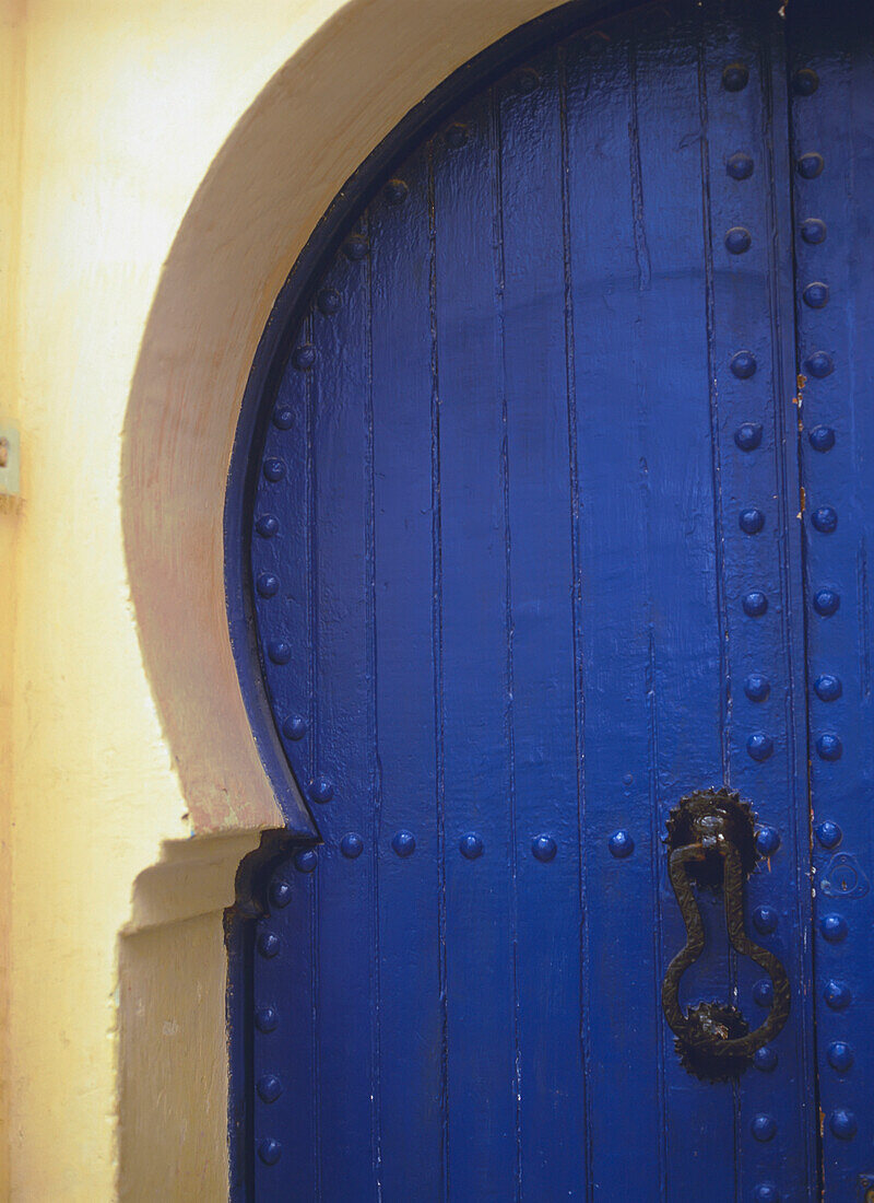 Marokko, gebogene blau-weiße Tür mit Türklopfer; Essaouira