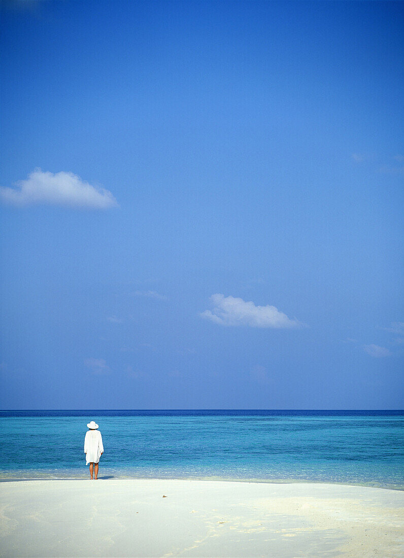 Woman In White Standing On Edge Of Tropical Beach