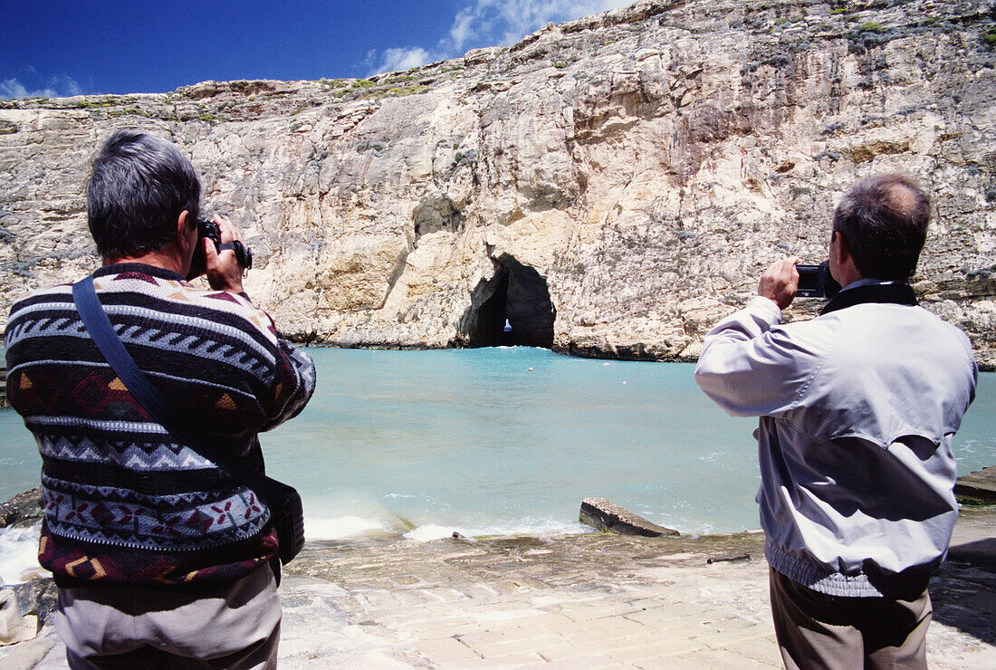 Two Men Videoing A Cave