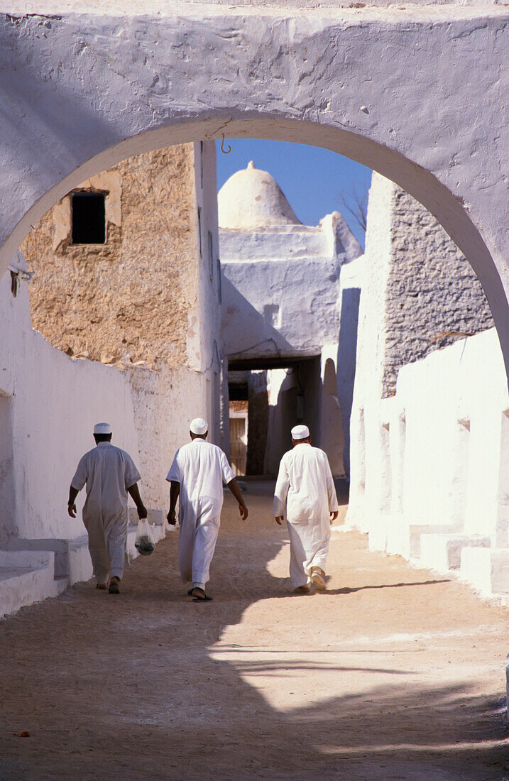 Three Men In Traditional Dress Walking In Old City