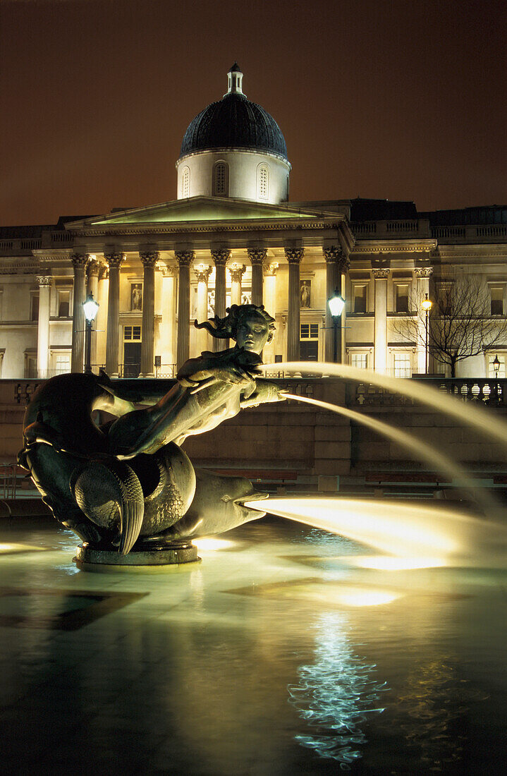 Blick auf den Trafalgar Square bei Nacht mit Springbrunnen und National Gallery