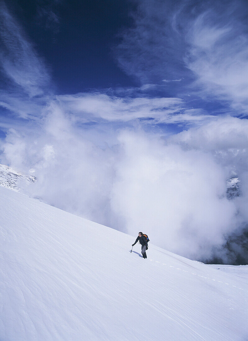 Woman Climbing Up Snowy Slope In The Sierra Nevada Mountains