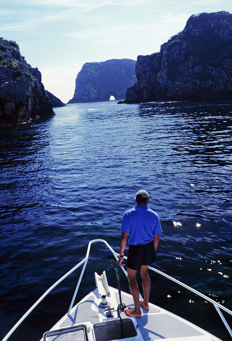 Crewman On Bow Getting Ready To Anchor In Cove