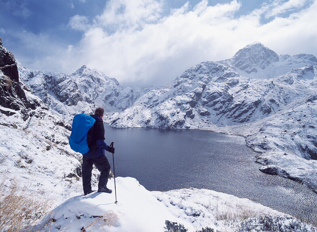 Frau bewundert Blick über See und verschneite Berge