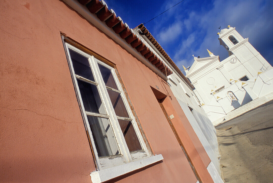 Rosa Haus und weiß getünchte Dorfkirche