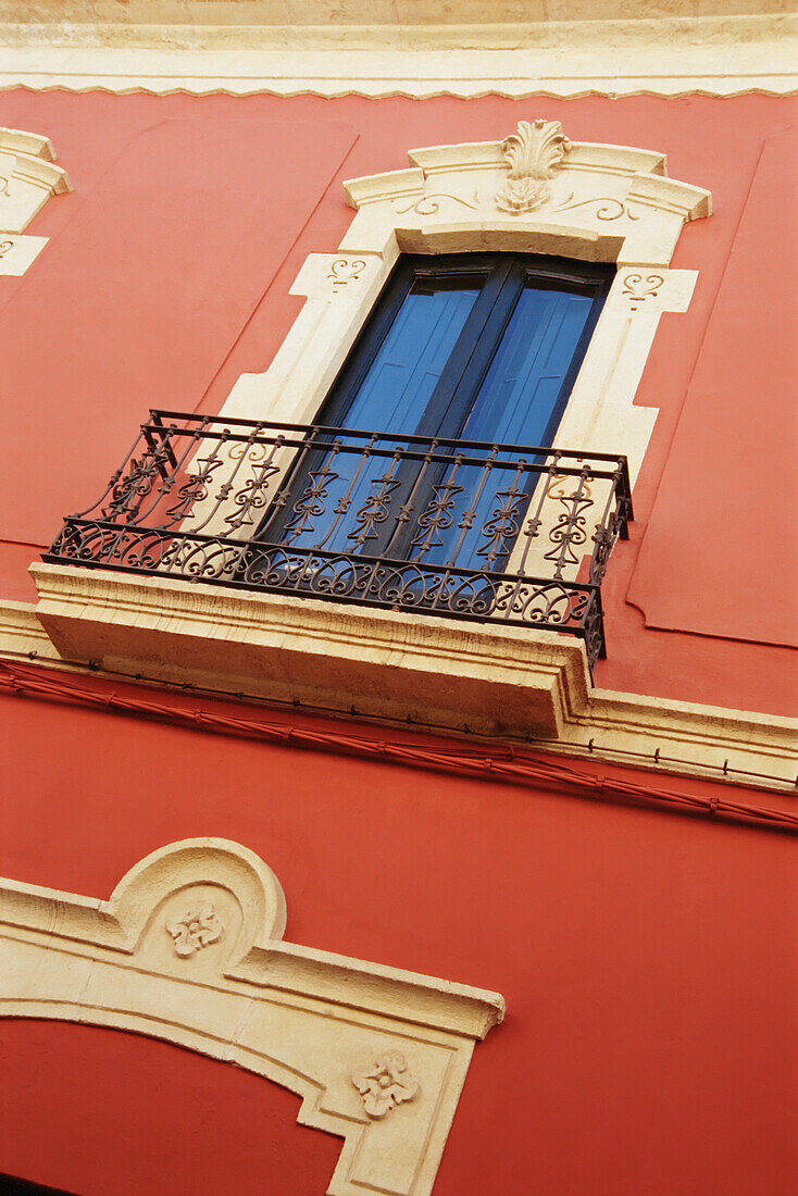 Detail eines Balkons und eines roten Gebäudes, Almeria
