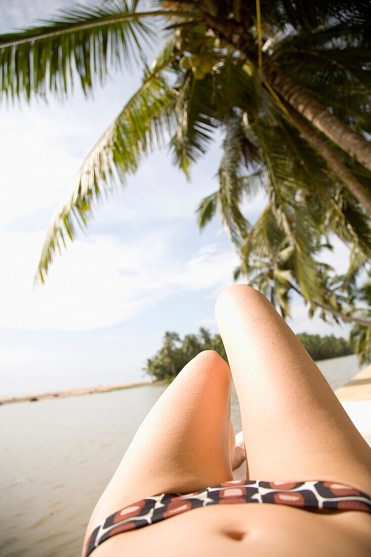Woman In Patterned Bikini Sunbathing On Tropical Beach