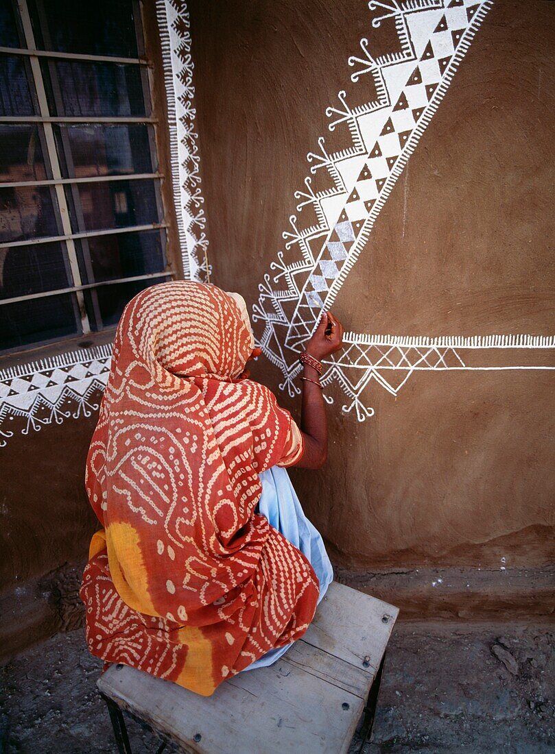 Woman Painting Home With Diwali Decorations