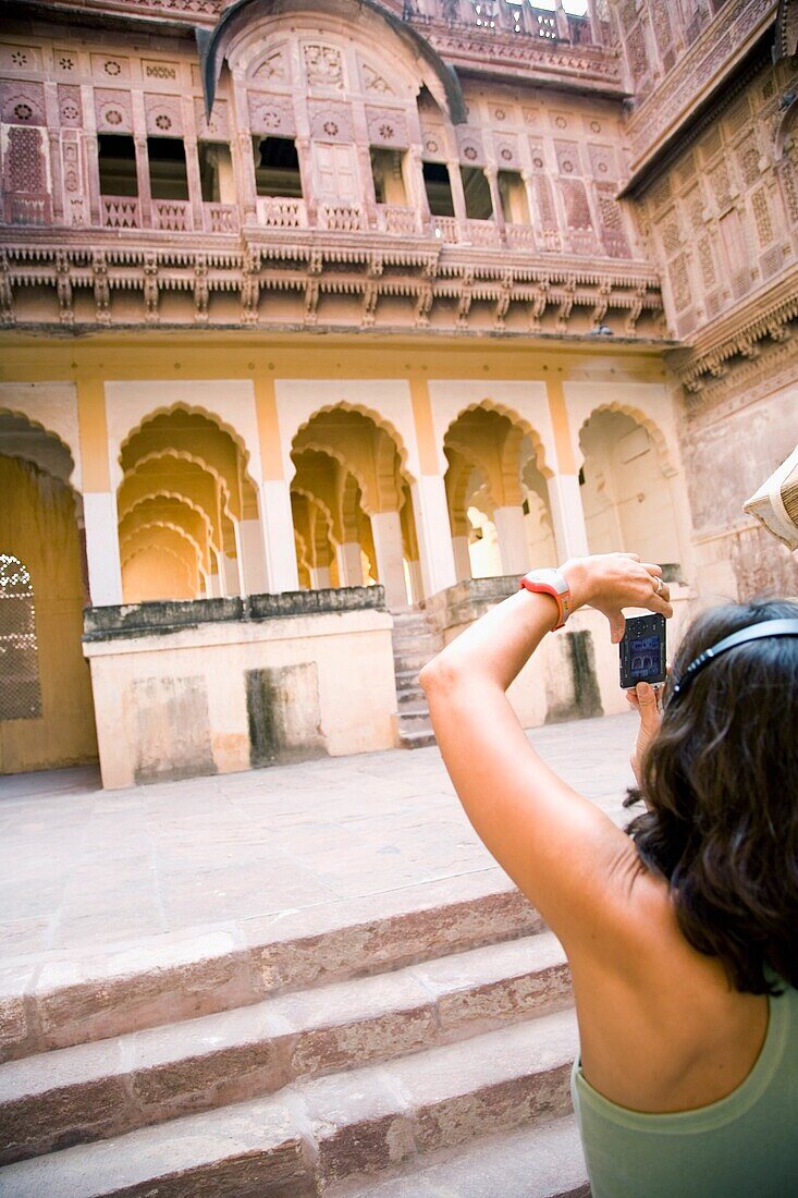 Woman Listening To Headphones Photographing At Fort Mehrangarh