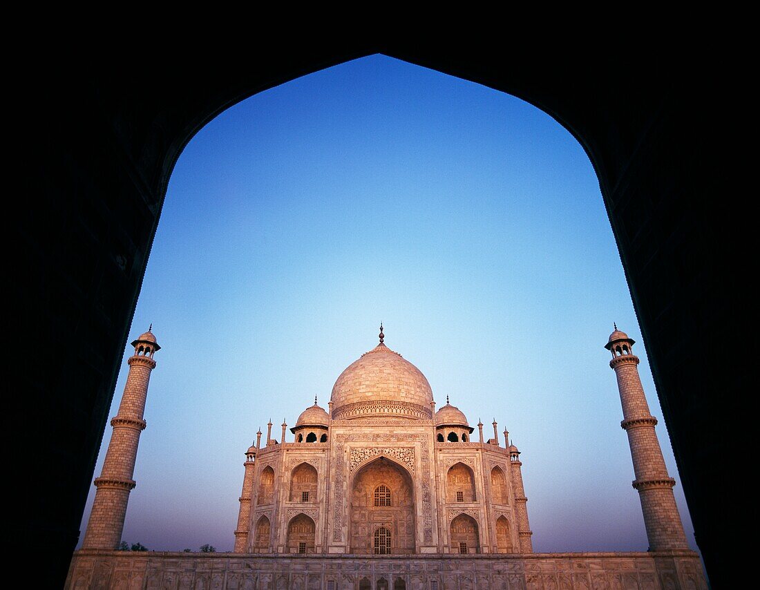 Das Taj Mahal in der Morgendämmerung durch einen Torbogen gesehen