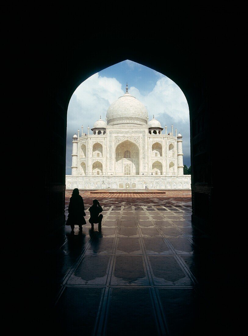 Silhouettierte Touristen im Bogengang des Taj Mahal