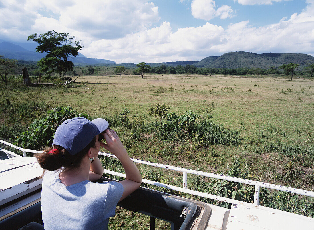 Woman On Safari Looking Over Grassland