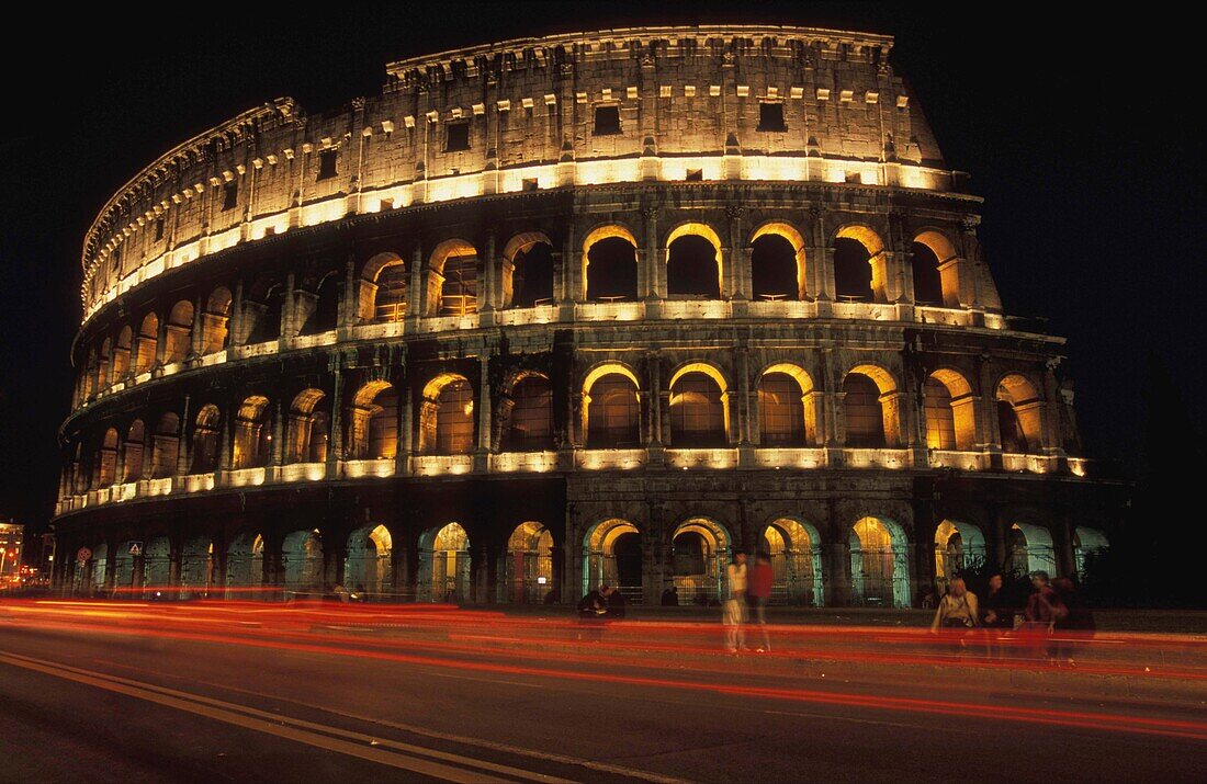 The Colosseum Lit Up At Night With Light Trails Infront