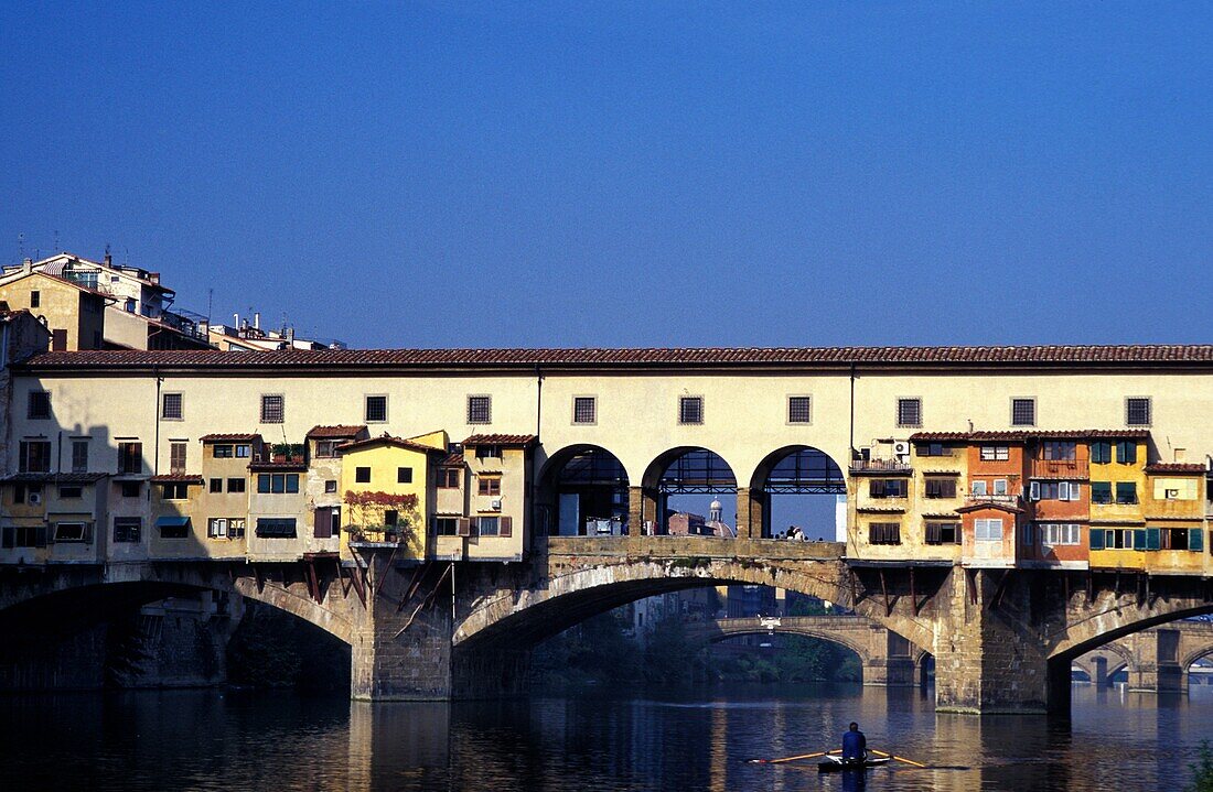 Mann rudert auf dem Arno am Ponte Vecchio