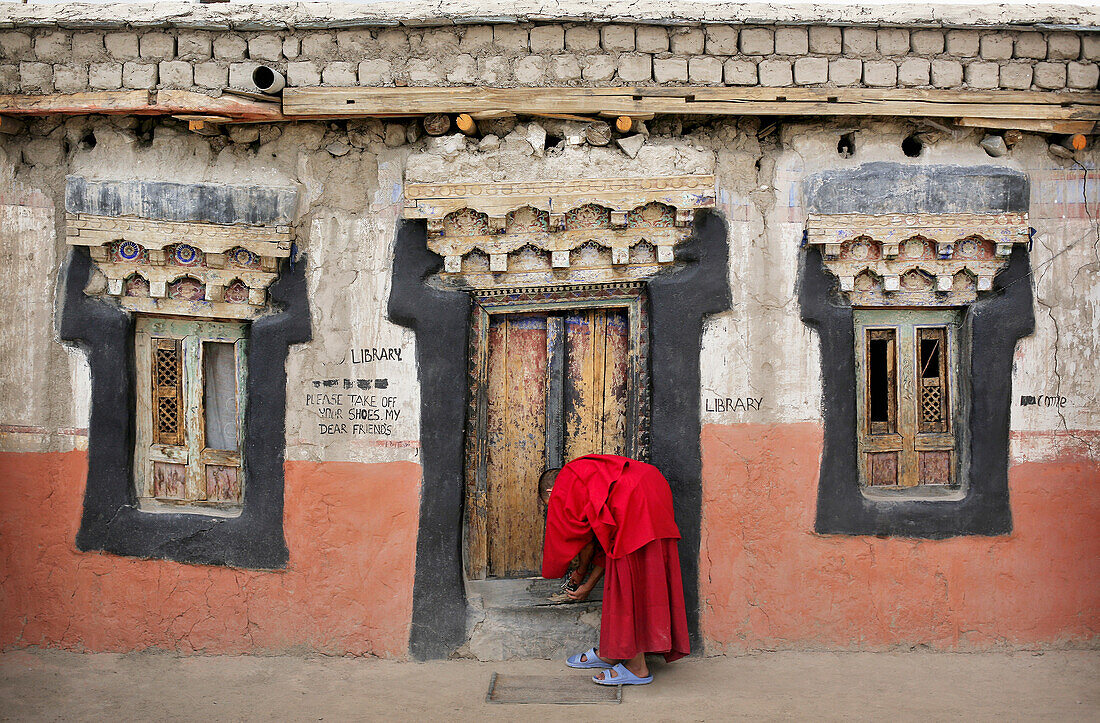 Buddhistischer Mönchsjunge verschließt die Tür des Klosters Thikse