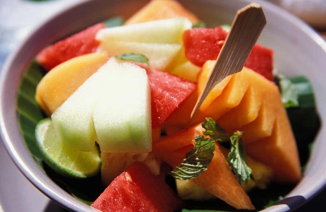 Eine Schale mit Wassermelone, Melone, Mango, Limette und Minze, Nahaufnahme