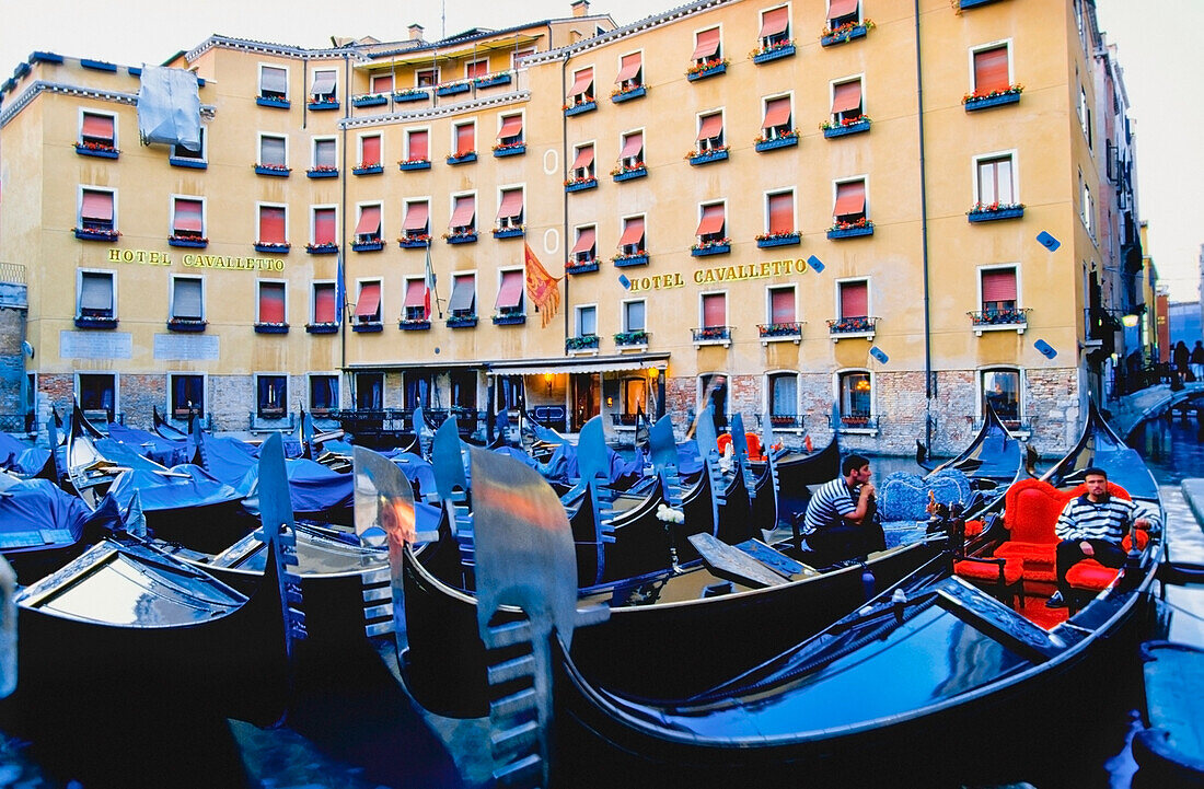 Gondoliers Sitting In Gondolas In Front Of Hotel Cavalletto