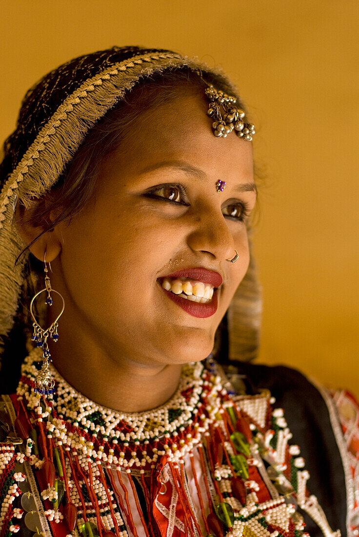 Lächelnde Frau in traditionellem Rajasthani Sari und Schmuck