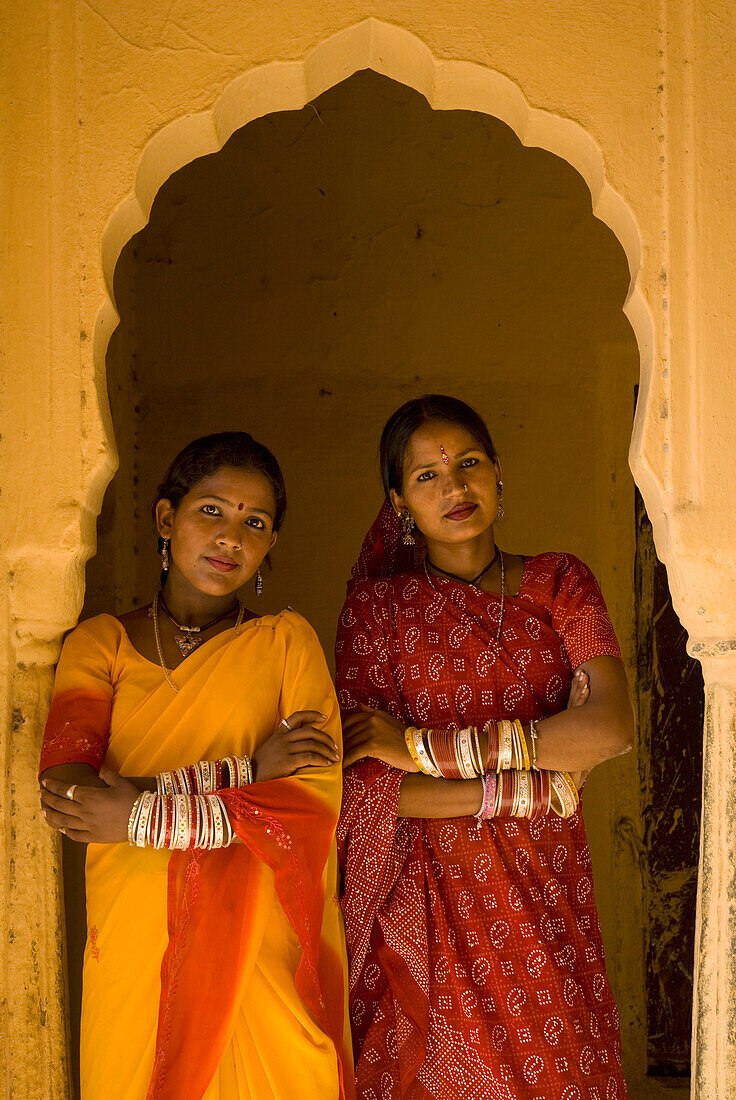 Zwei Frauen in Saris im Bogengang eines alten Gebäudes