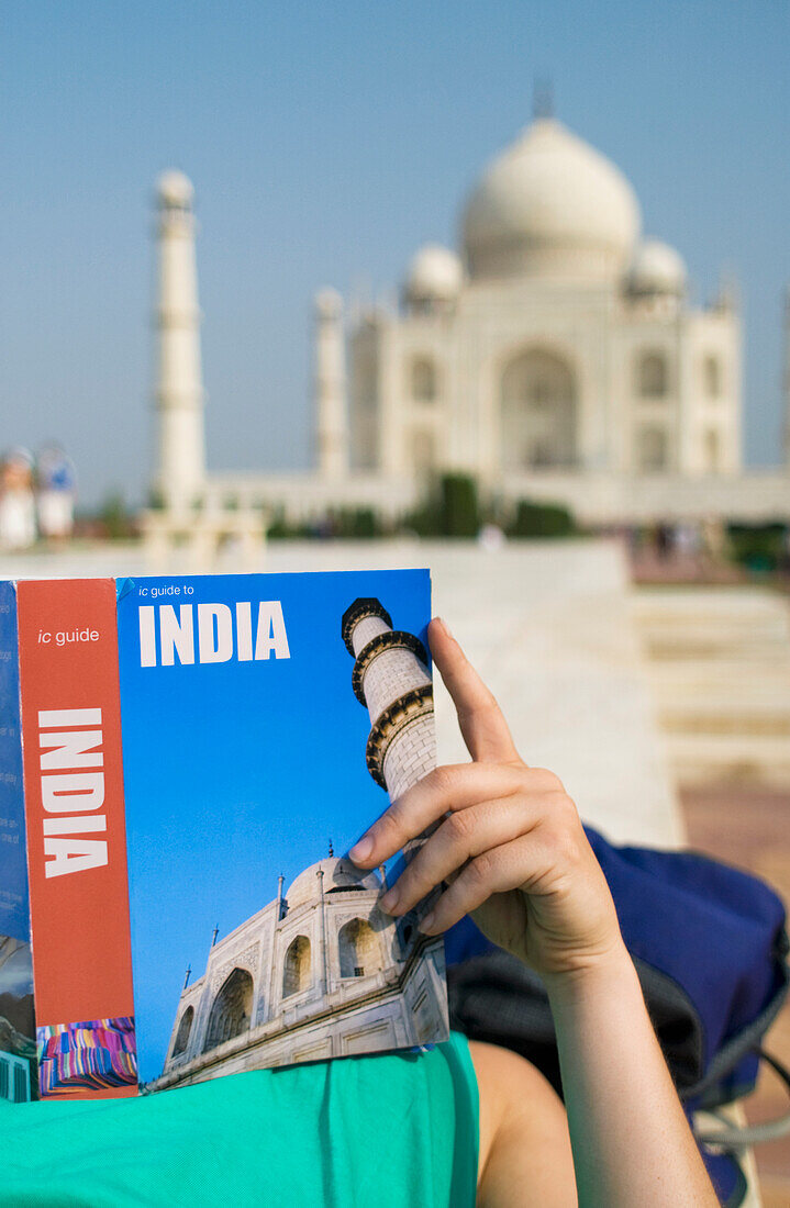 Frau liest Reiseführer vor dem Tadsch Mahal, Nahaufnahme
