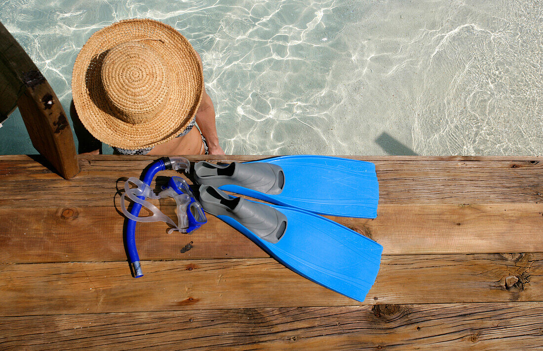 Frau am Strand stehend in klarem Wasser.