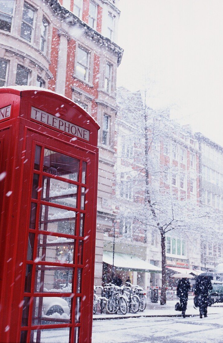 Snow Falling On Red Telephone Box In Marketplace