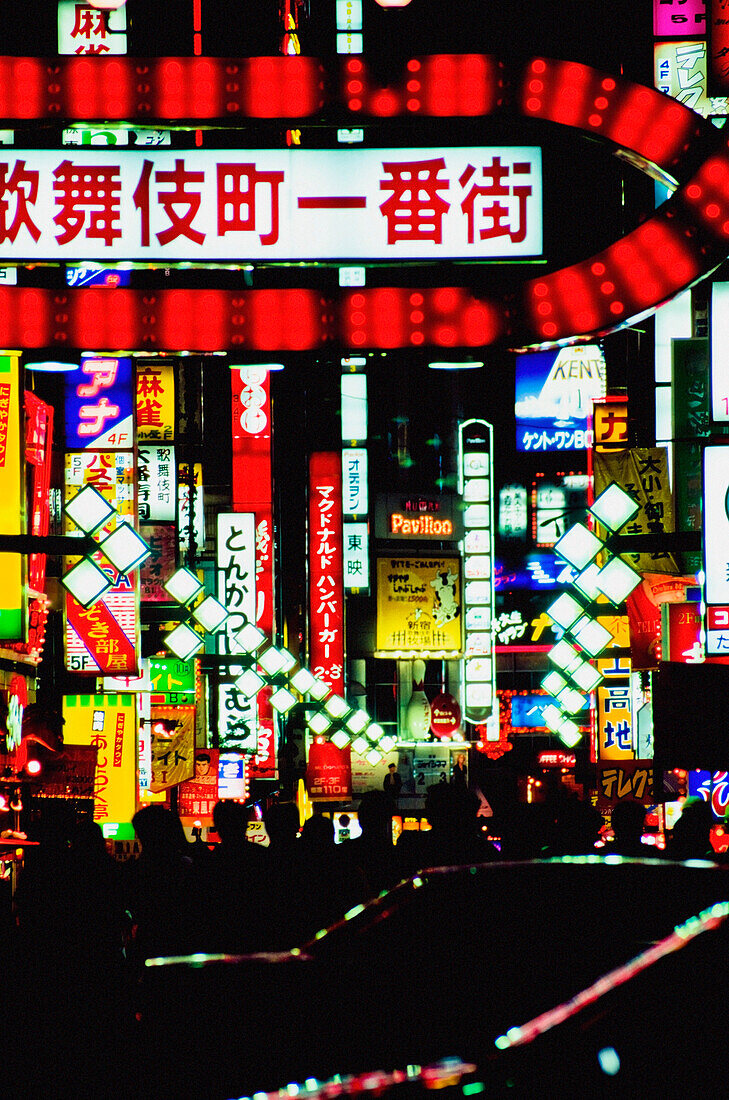 Neonschilder über belebter Straße bei Nacht