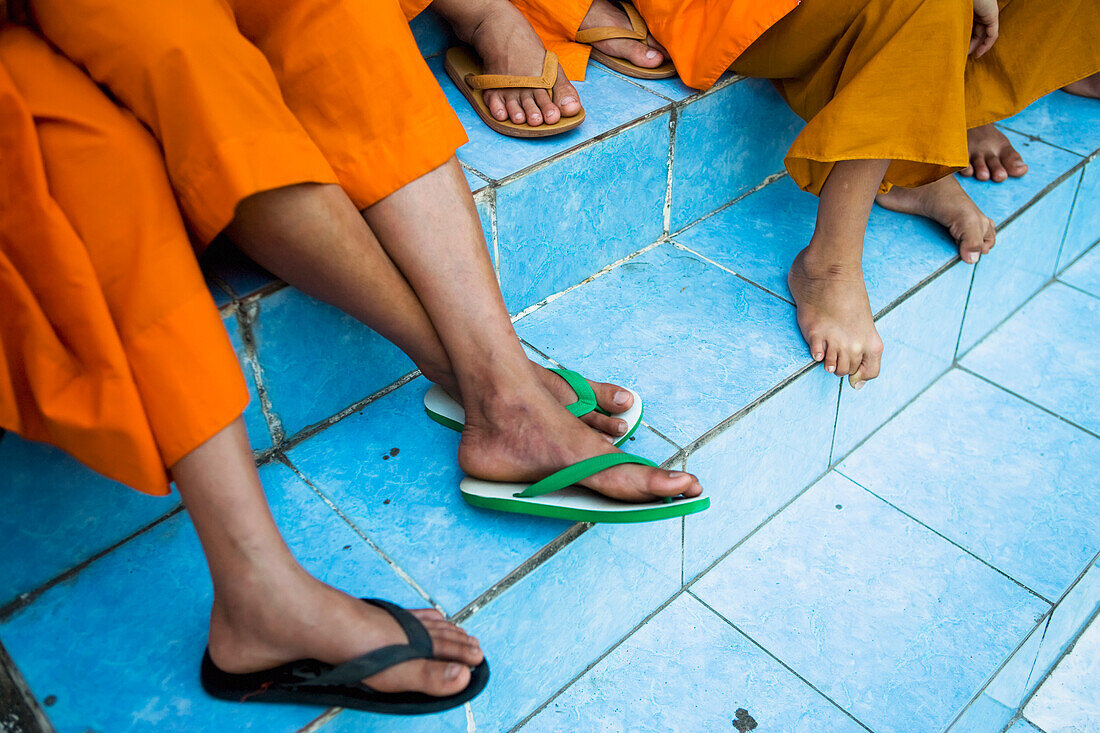 Novizen Mönche sitzen auf den Stufen des Wat Sensoukharam.
