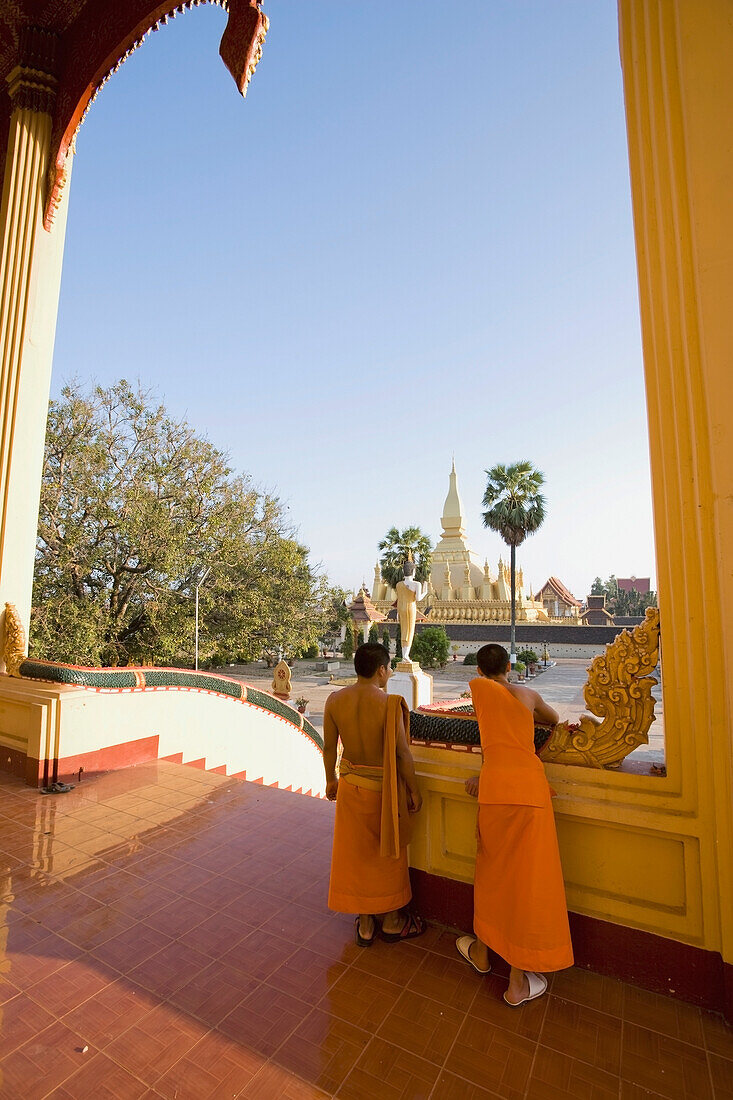 Mönche, die auf den Stufen des Wat That Luang Tai stehen.