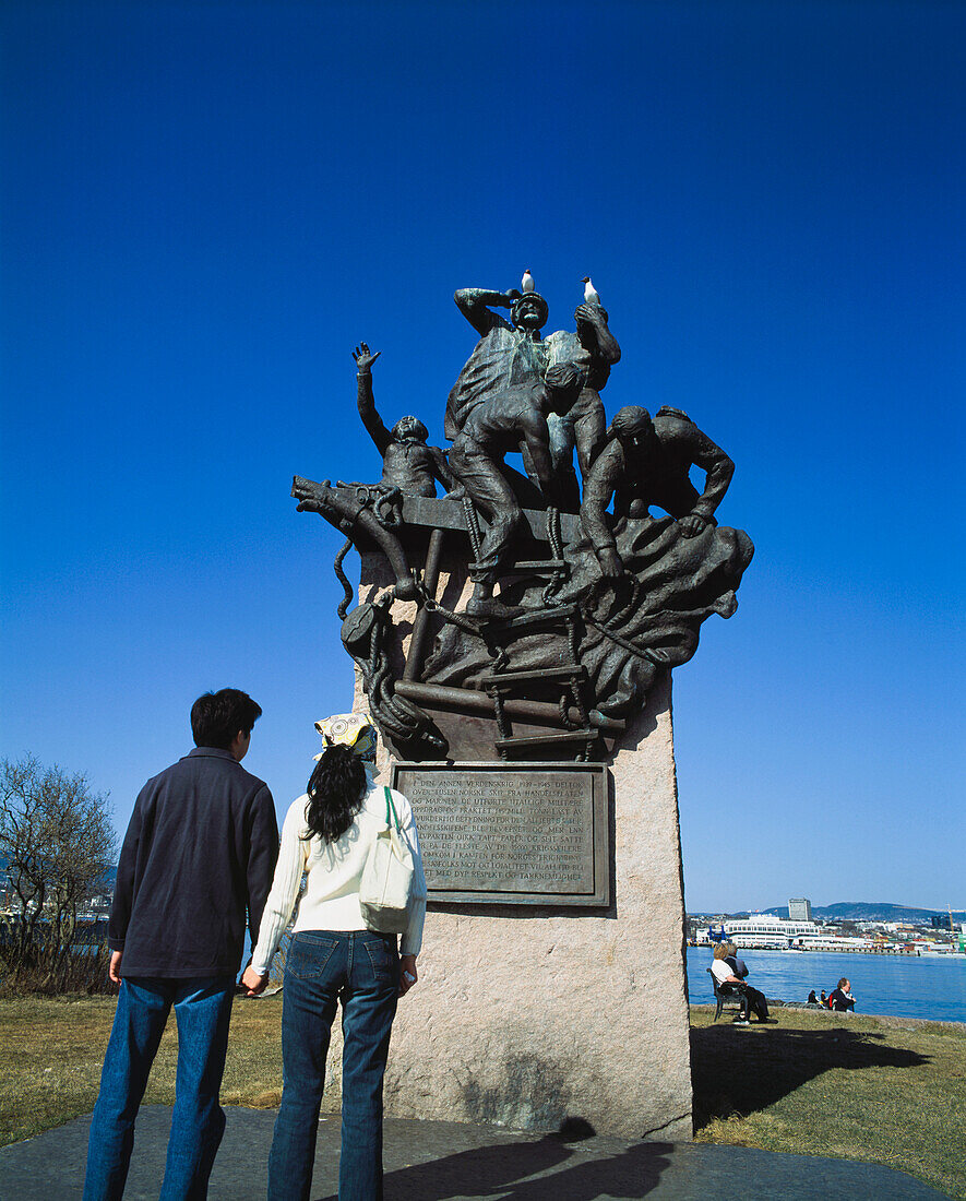 Young Couple Looking Up At A Statue Commemorating Sailors On Bygdoy Peninsula.