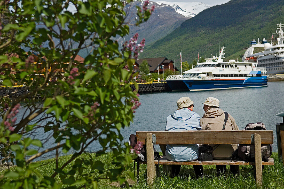 Ein Paar alter Damen auf einer Bank neben Kreuzfahrtschiffen sitzend