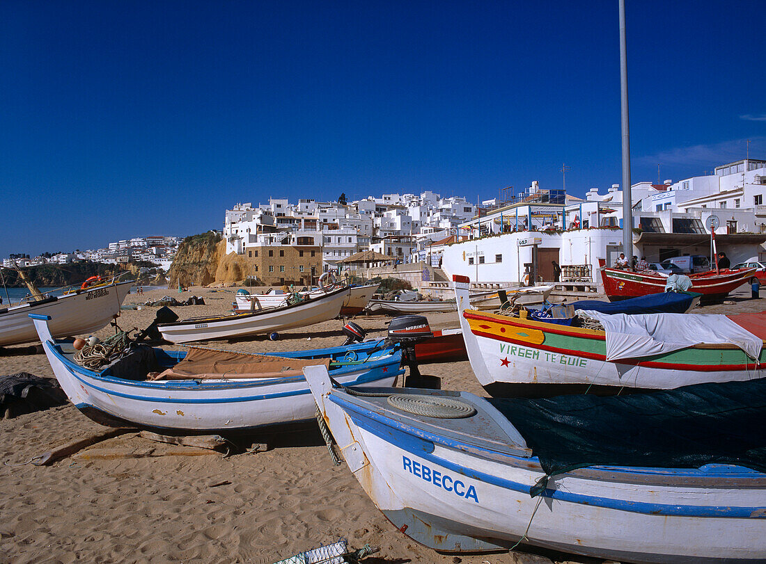 Whitewashed Buildings And Beach With Boats On Sand