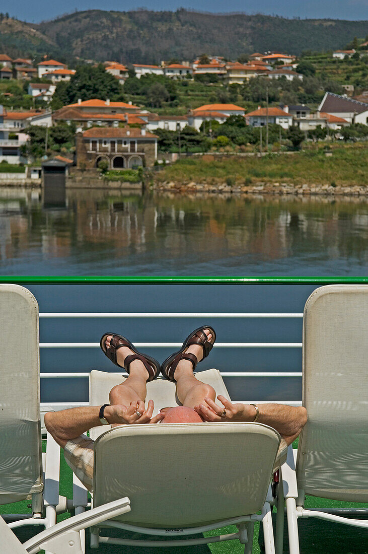 A Man Relaxing On Deck Aboard A Douro Valley River Cruise