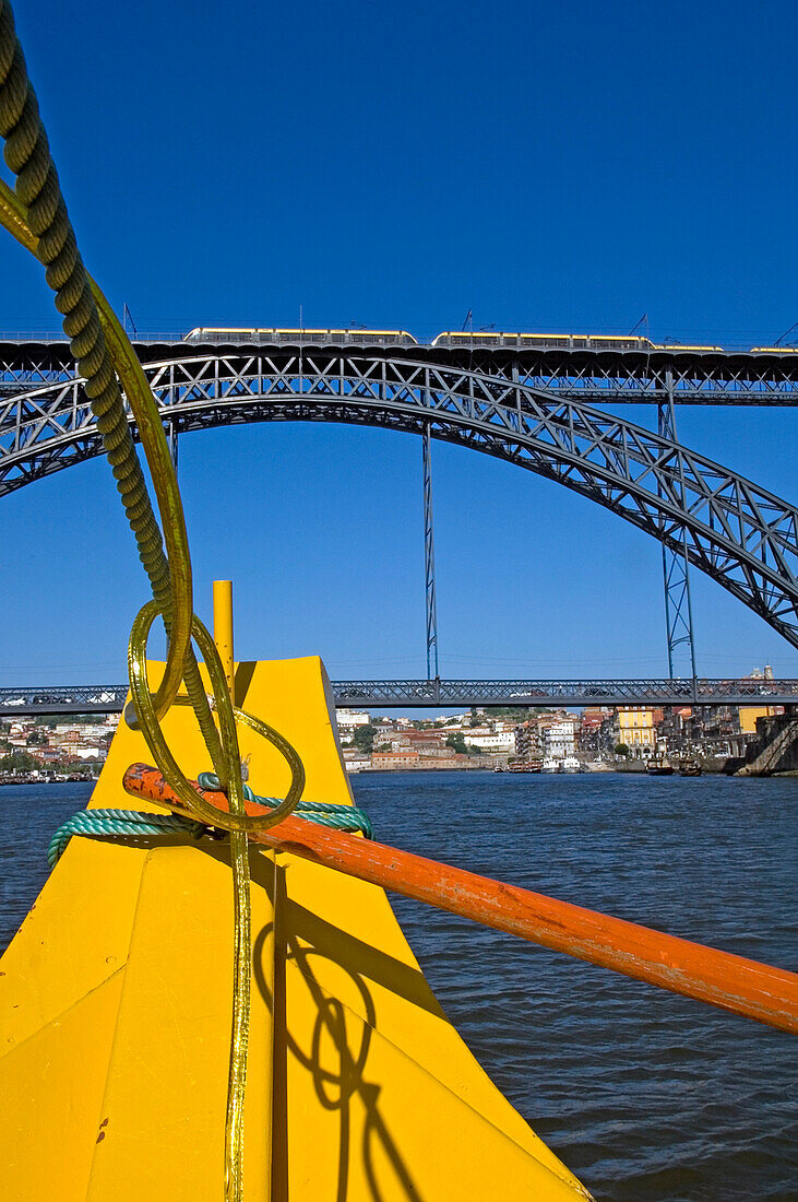 A Yellow Cruise Boat On River Douro Passing Under Bridge