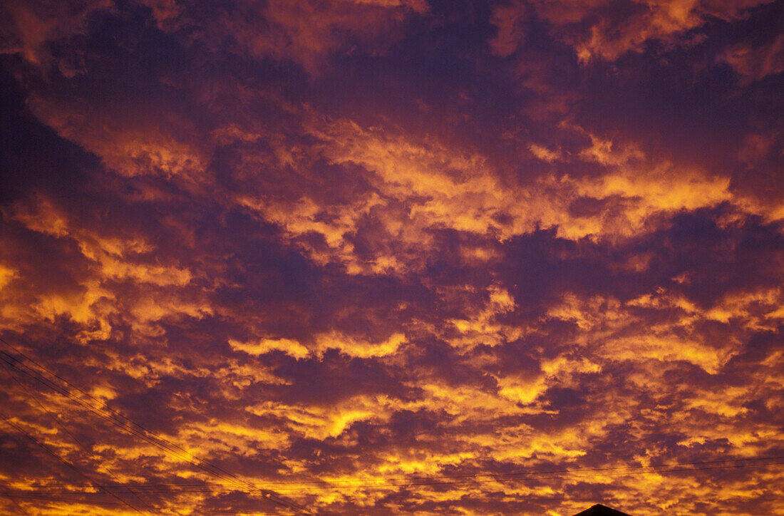 Mountaintop Silhouetted Against Pink And Purple Clouds