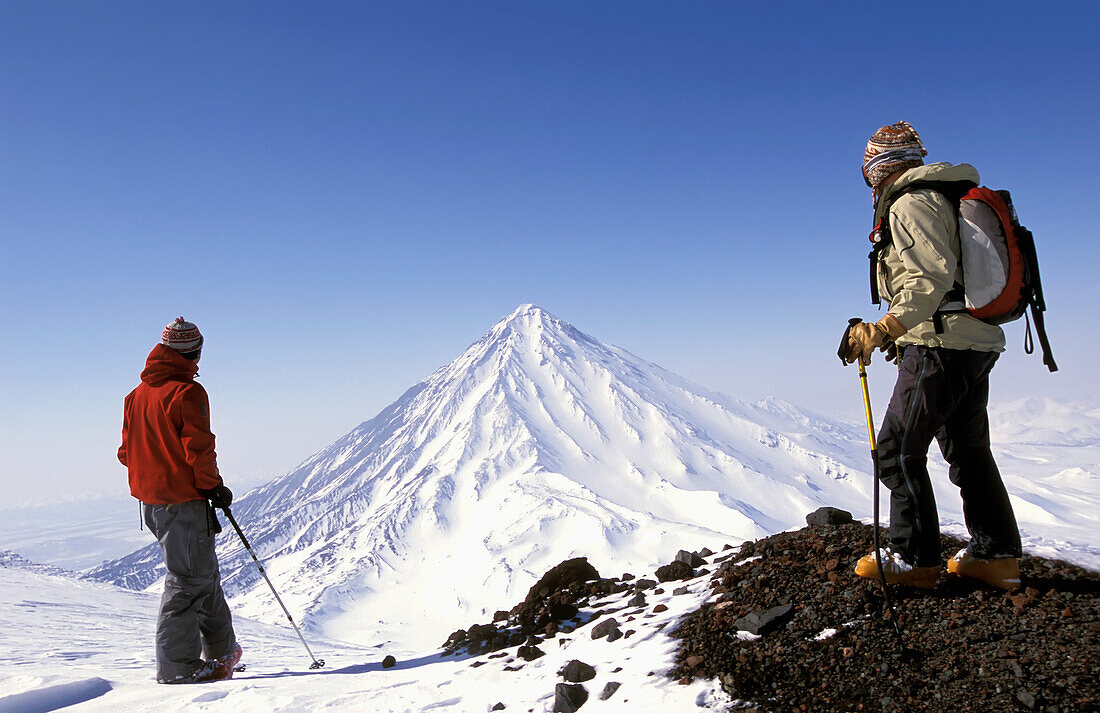 Zwei Skifahrer bewundern einen verschneiten Gipfel