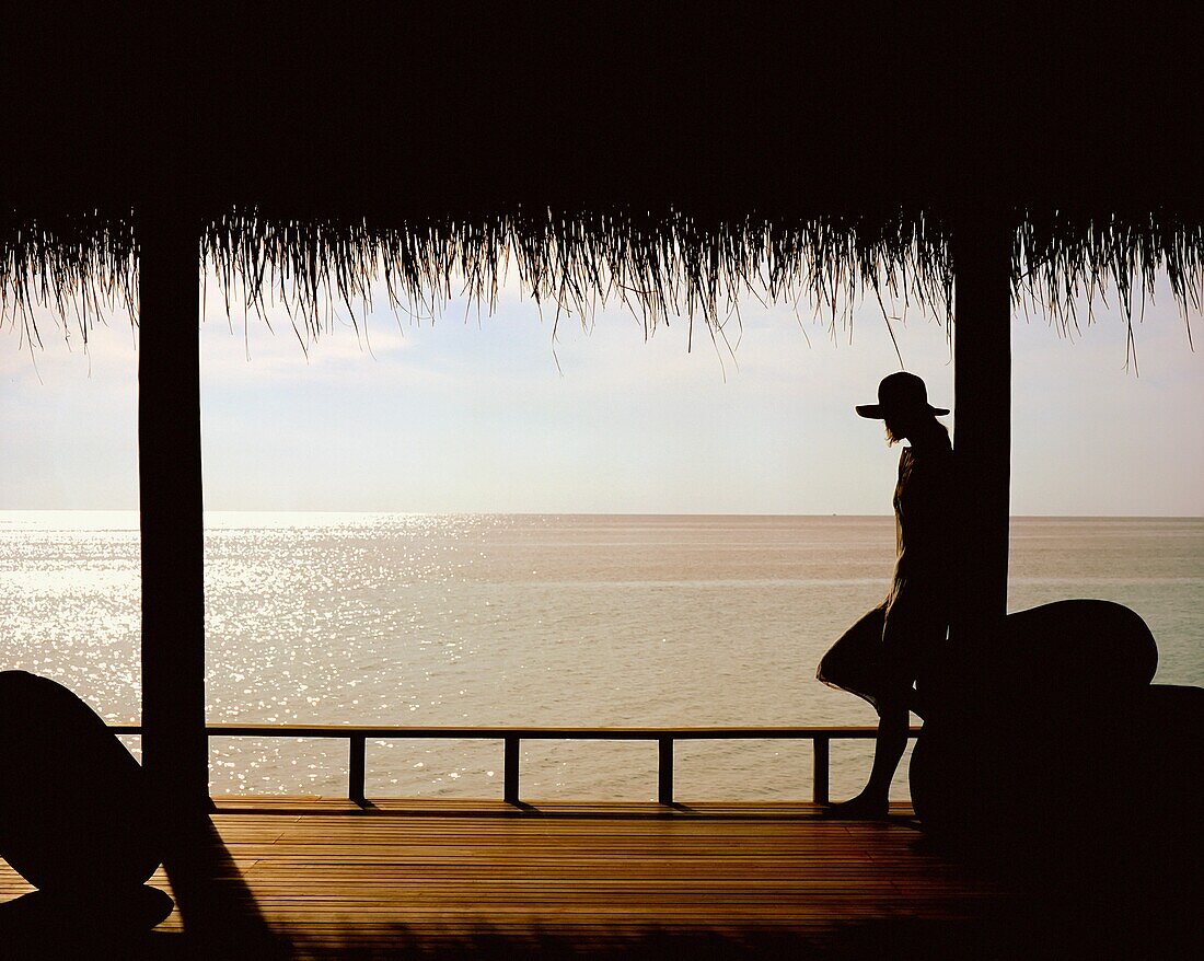 Frau auf Veranda mit Blick auf den Ozean