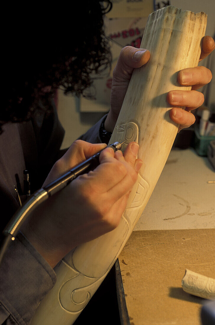 Alaskanischer Elfenbeinschnitzer bei der Arbeit an einem Stück Ak Studio/Njohn Koschman