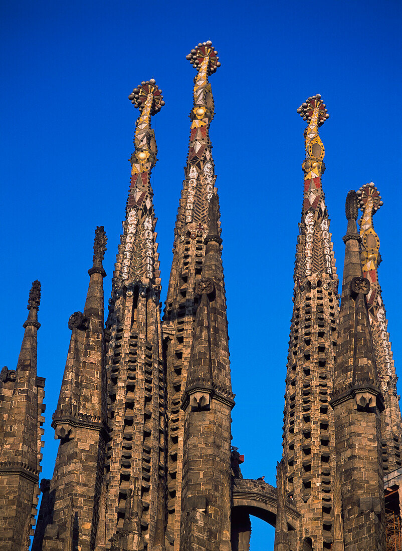 Tourist zu Fuß zwischen den Türmen der Sagrada Familia in der Abenddämmerung