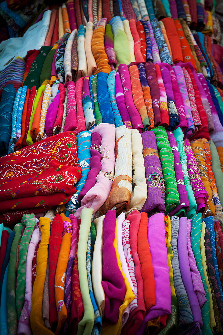 Eine Vielzahl bunter, in Reihen gefalteter Stoffe; Jodhpur, Rajasthan, Indien